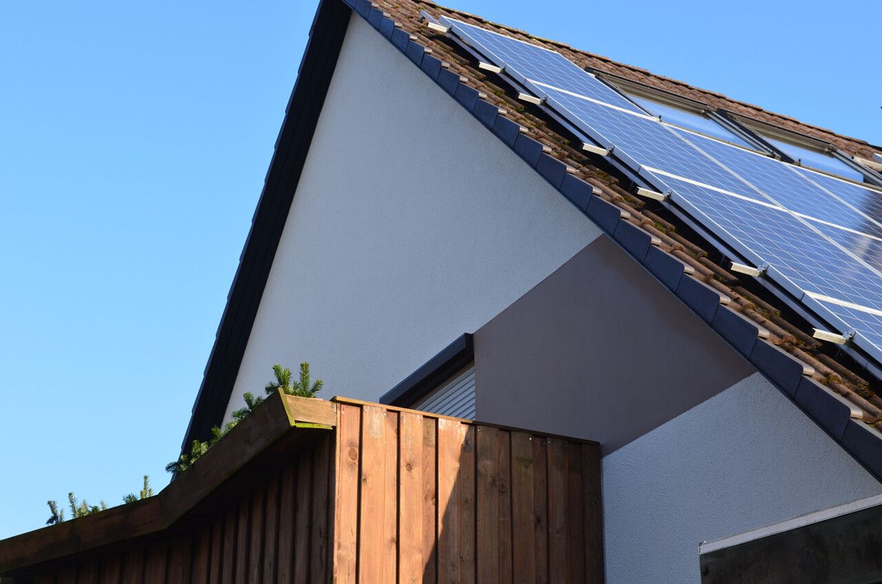 Außenansicht eines Hauses mit Solaranlage und blauem Himmel